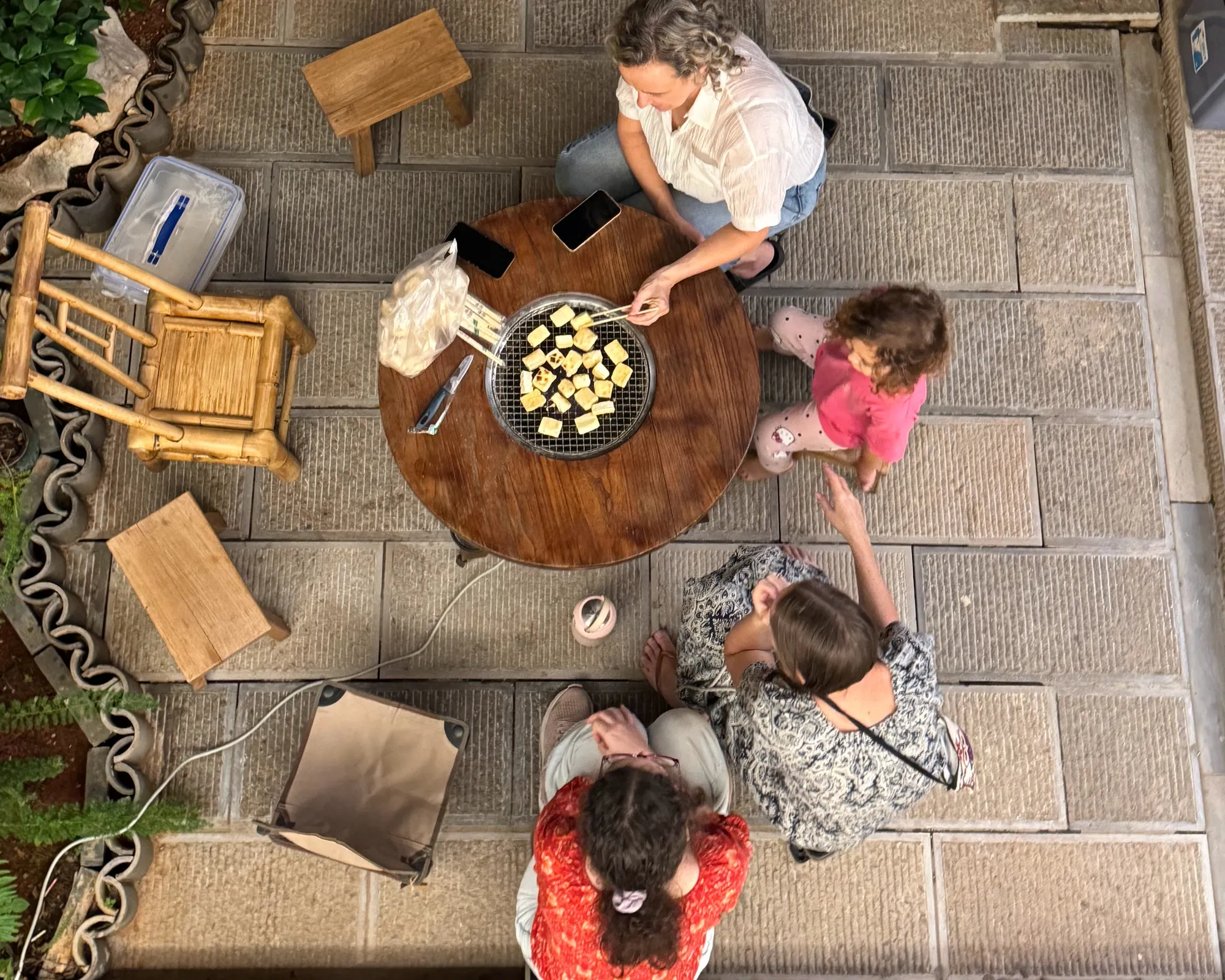 Family learning to grill ceremonial tofu in Jianshui
