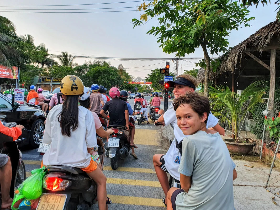 Kids riding ebike in An Bang Beach, Vietnam - family travel guide